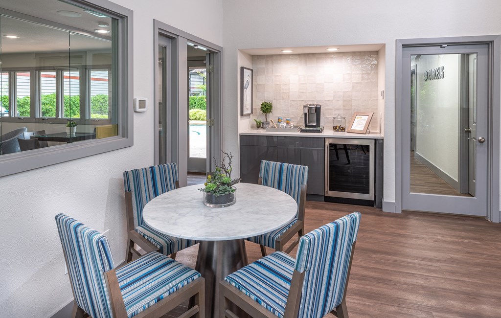 A modern dining room with a round table and striped chairs.